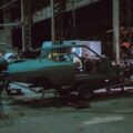 people inside building with tools and unfinished cars