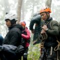 A group of people wearing helmets and climbing gear