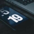 black smartphone beside laptop